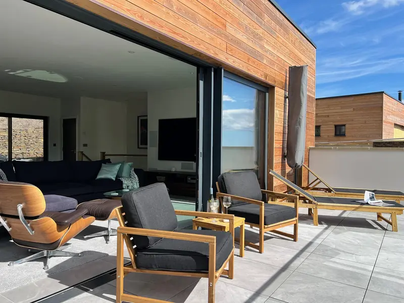 Terrace loungers beside the open glass doors to the living room