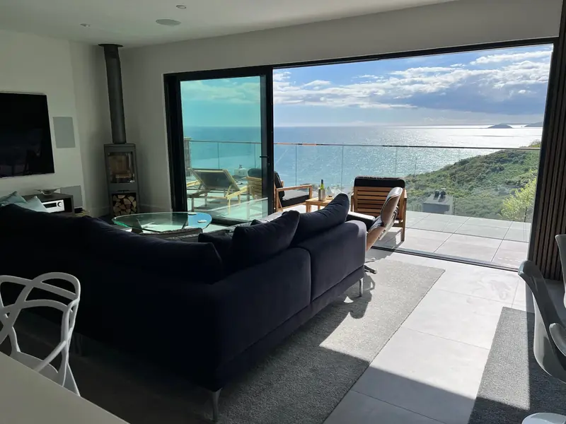 Living room with sofa and wide sea view through glass doors